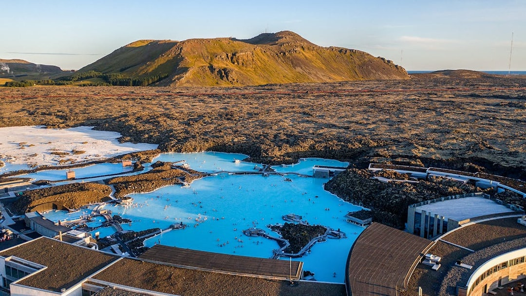 Blue Lagoon geothermal pool with surrounding lava fields in Iceland.