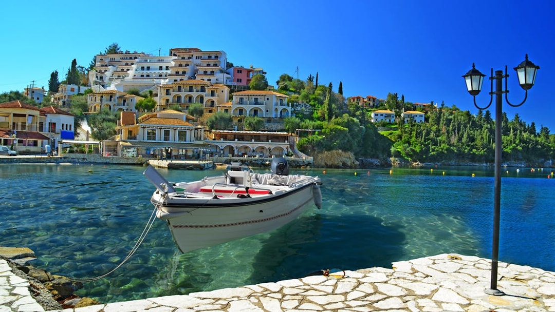 Boat docked in Sivota harbor with hillside buildings, part of Blue Lagoon & Sivota Cruise from Corfu.