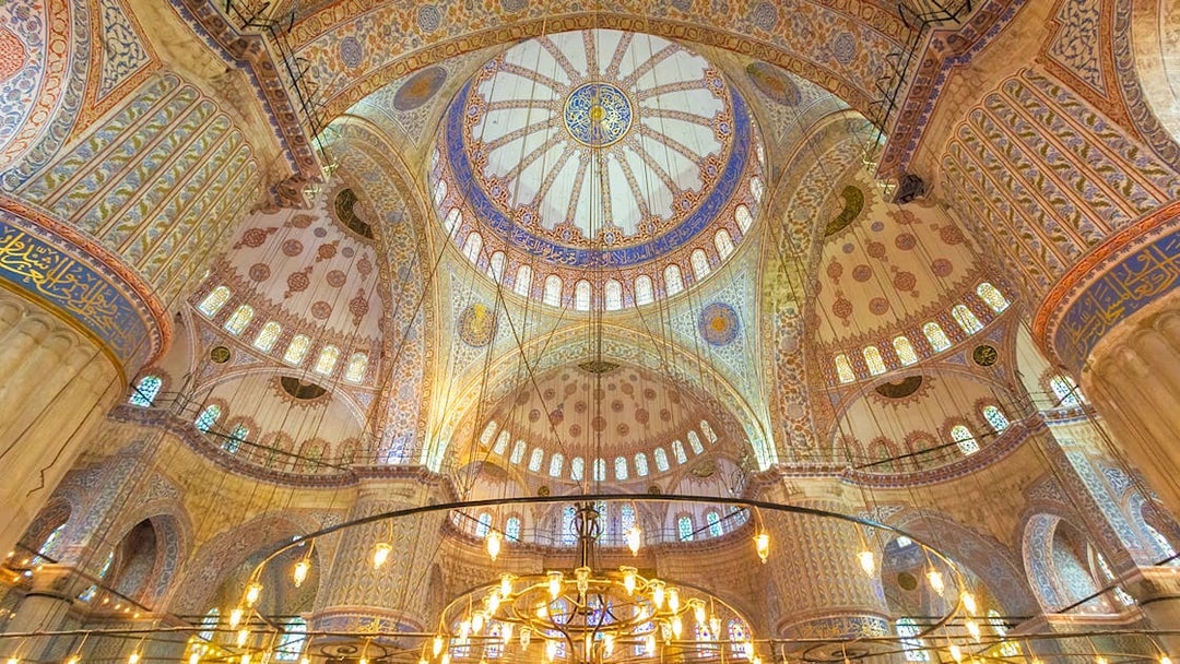 Blue Mosque interior with ornate domes and intricate patterns, Istanbul.