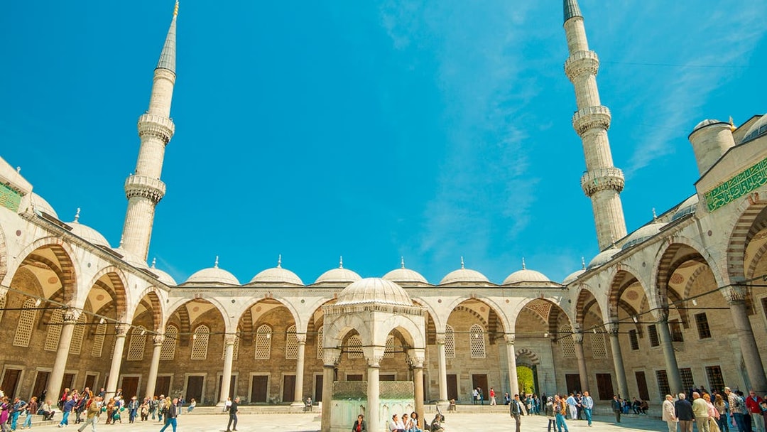 Blue Mosque courtyard with visitors, Istanbul, minarets in view.
