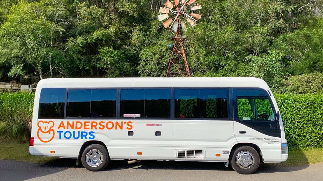 Tour bus for Blue Mountains All-inclusive Day Tour parked near a windmill.
