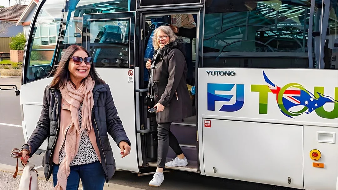 Tourists boarding a bus in Sydney for a full-day Blue Mountains tour.