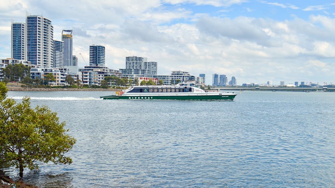 Ferry cruising along Parramatta River with city skyline in the background.