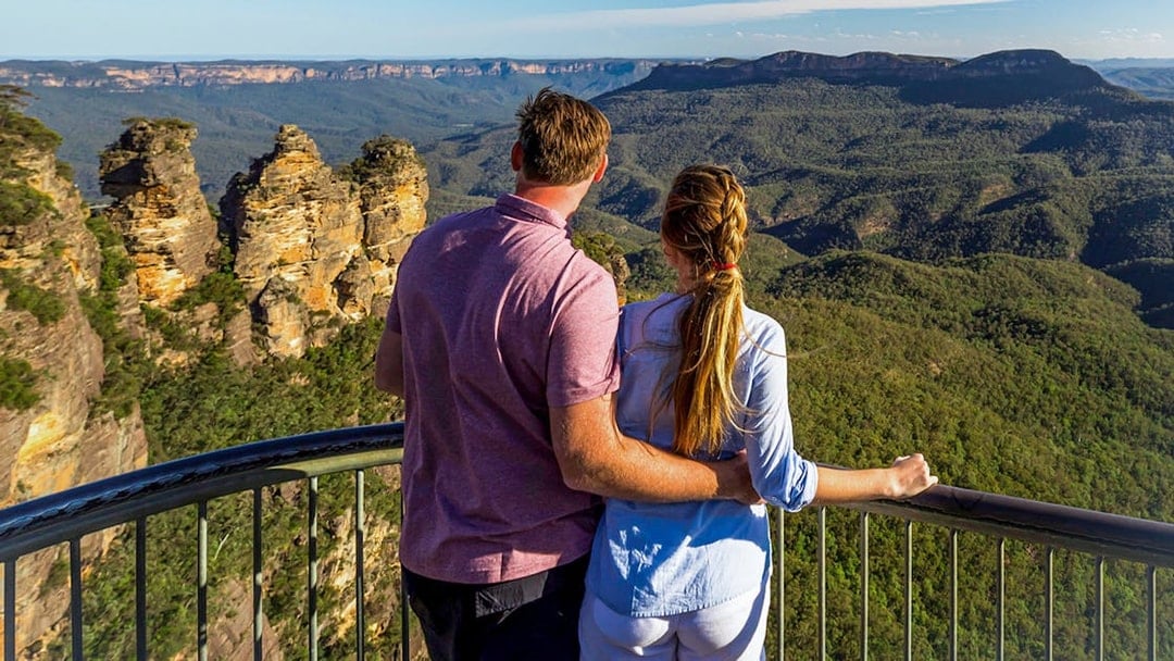 Couple admiring the Three Sisters rock formation in Blue Mountains, Australia.