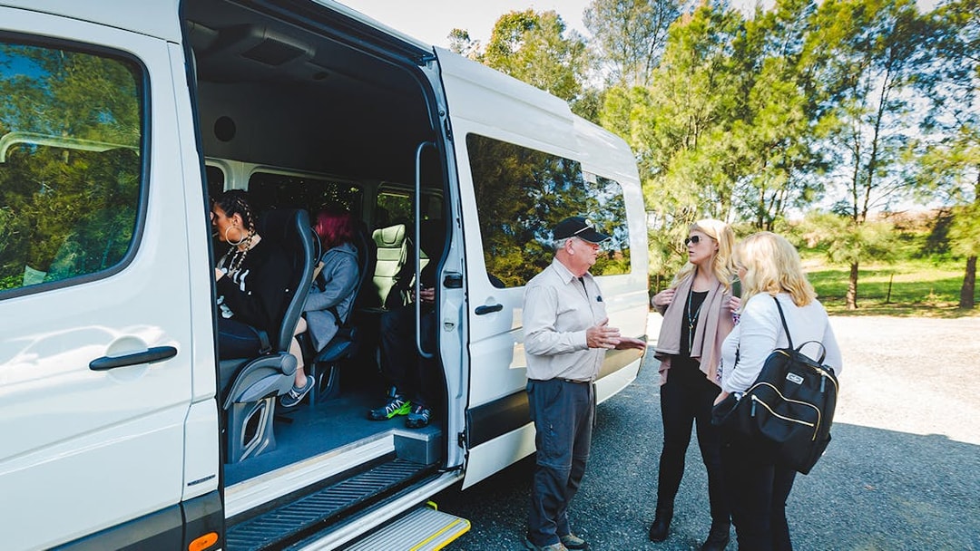 Luxury coach pickup for Blue Mountains guided tour with passengers boarding.