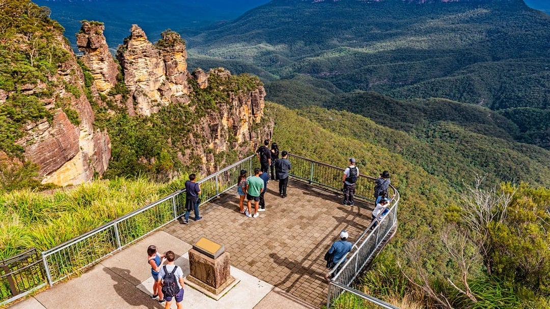 Visitors at Echo Point lookout viewing the Three Sisters rock formation in Blue Mountains, Australia.
