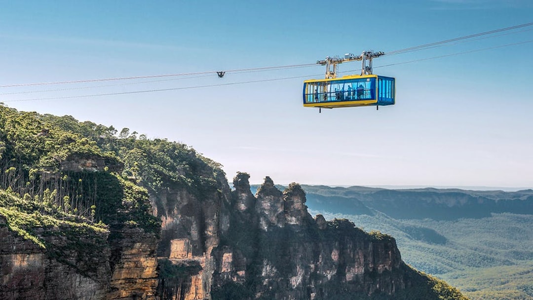 Scenic Skyway cable car over Blue Mountains, Australia, with forested cliffs below.