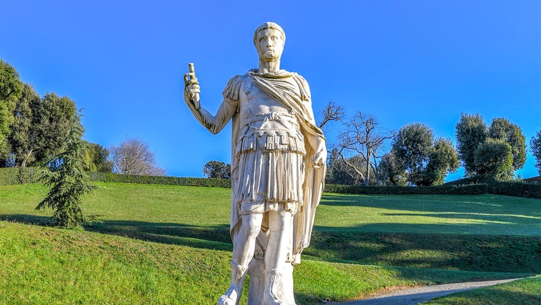 Statue of a Roman figure holding a scroll in Boboli Gardens, Florence.