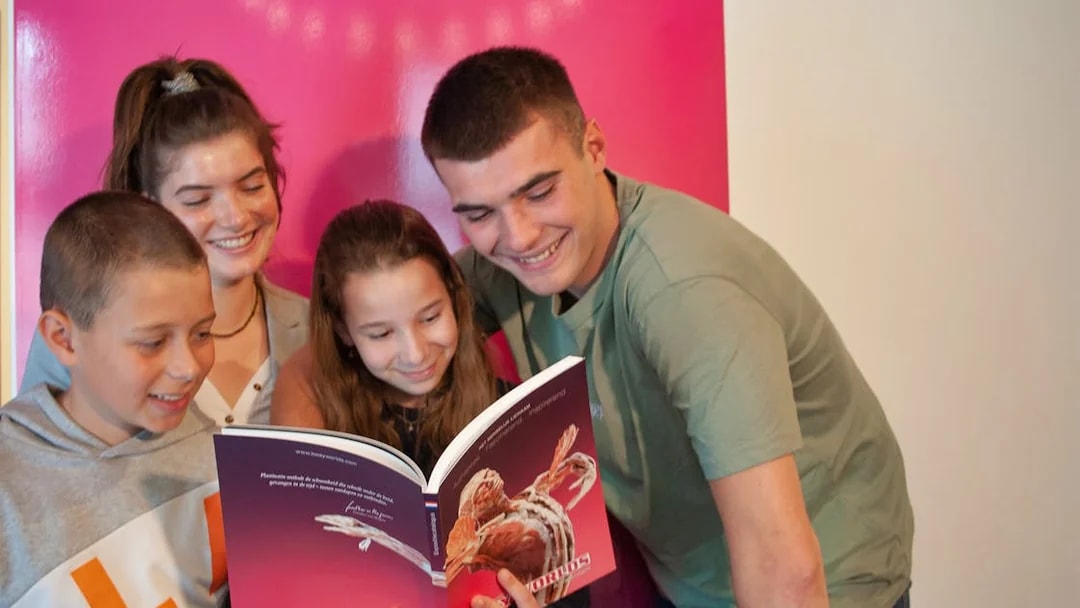 Group of people reading a Body Worlds Amsterdam book together.