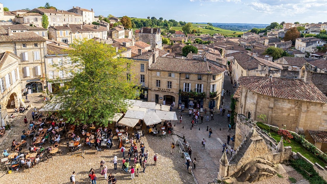 Saint-Emilion village square with outdoor café and historic architecture.