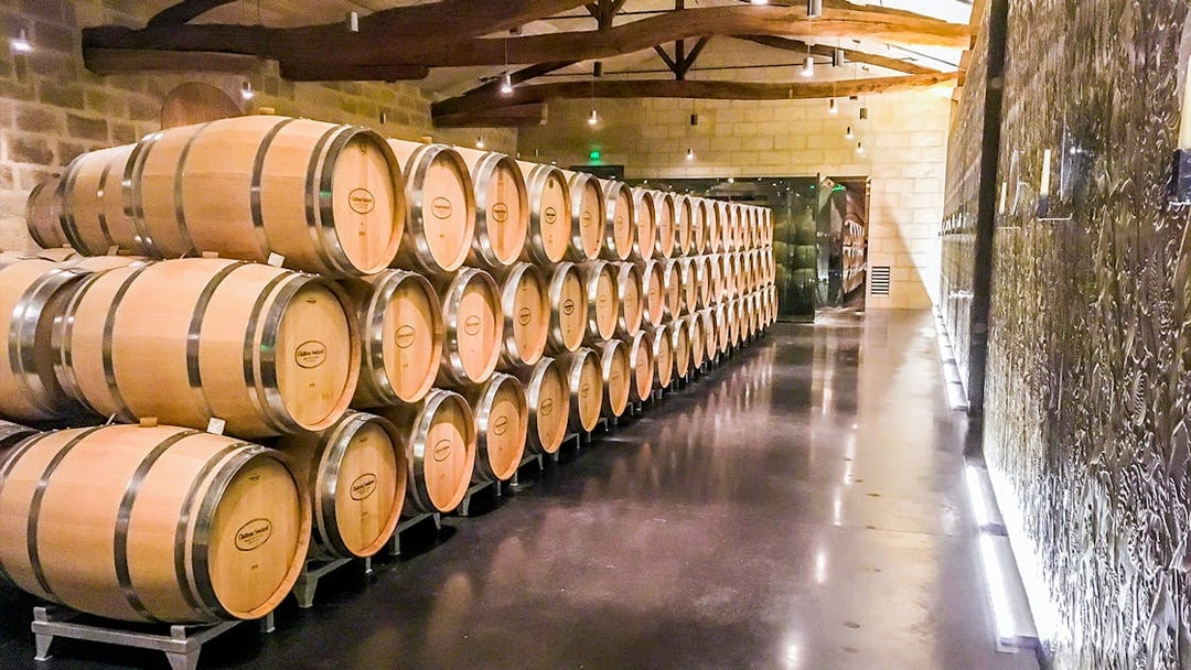 Wine barrels in a cellar during a Saint-Emilion Grand Cru tour.