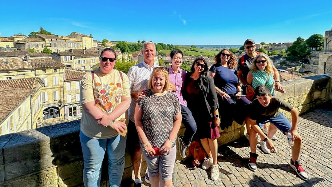Group enjoying a tour in Saint Emilion with village and vineyard views.