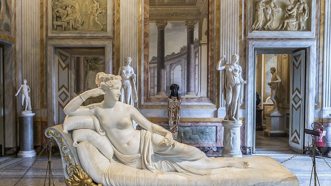 Borghese Gallery sculpture room with reclining marble statue and classical decor.