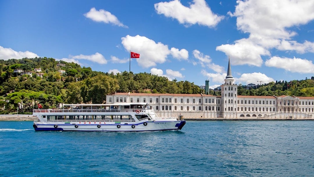 Tour boat on the Bosphorus with Kuleli Military High School in the background, Istanbul.