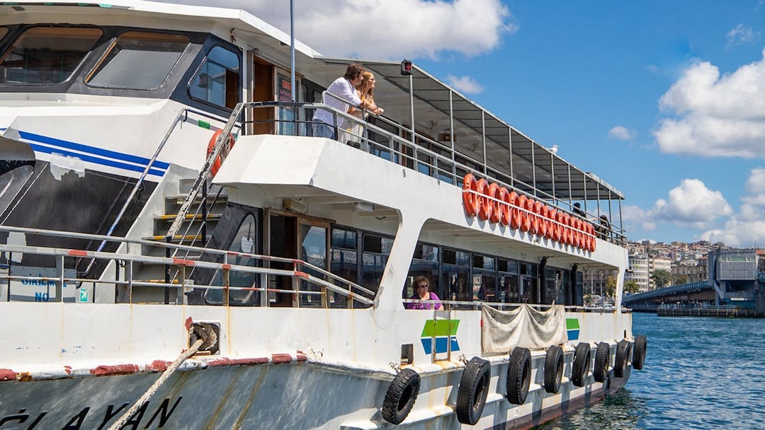 Tourists on a boat enjoying the Istanbul Bosphorus sightseeing cruise with an audio guide.