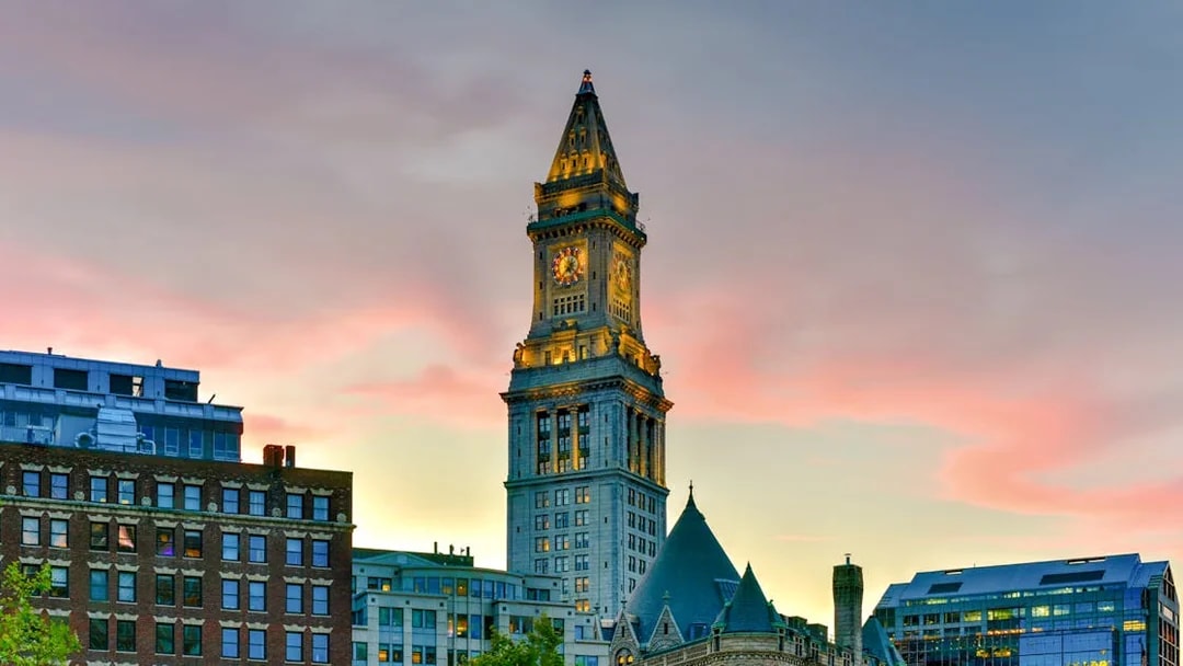 Custom House Tower in Boston at sunset with surrounding buildings.