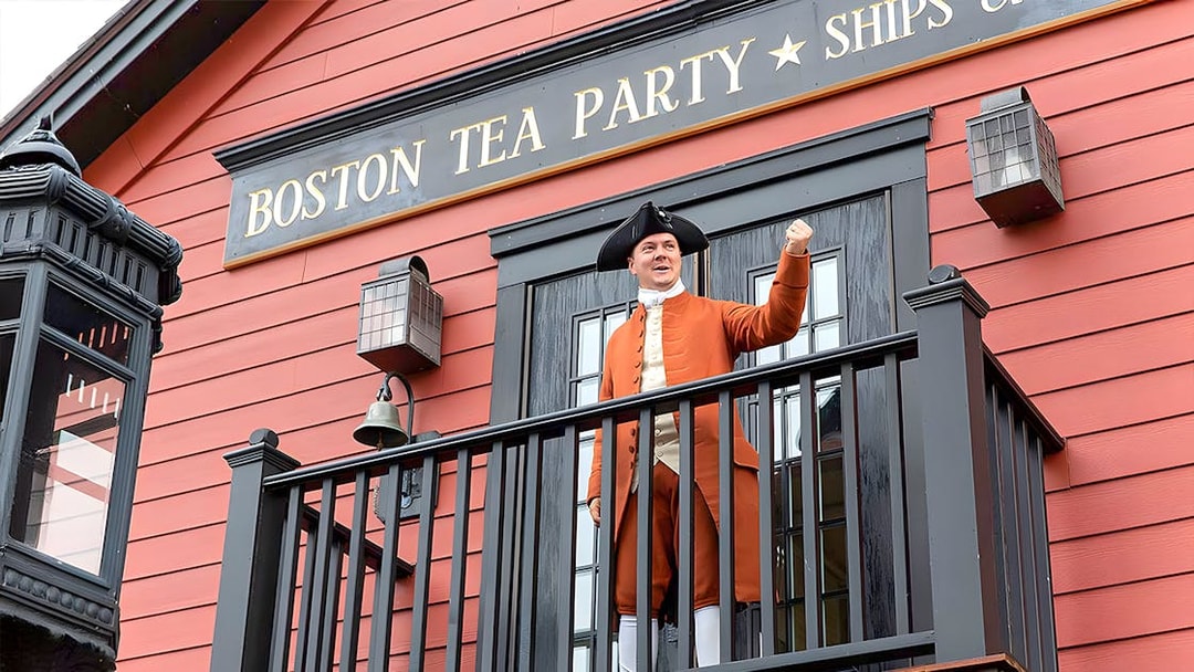 Boston Tea Party Ship and Museum exterior with historical reenactor on balcony.