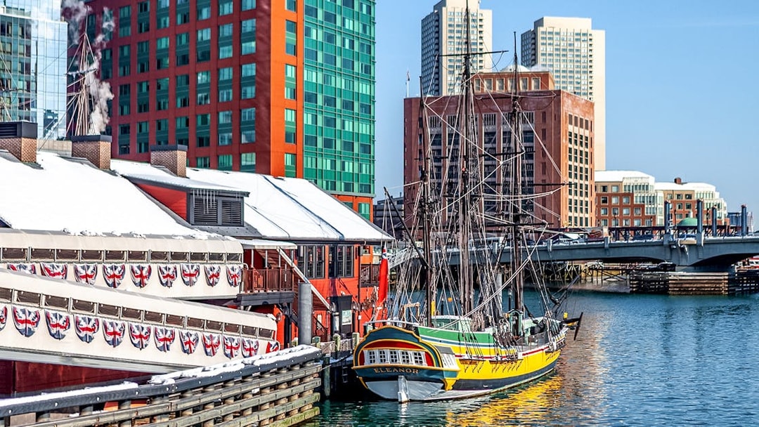 Boston Tea Party Ship docked near historic buildings and waterfront.