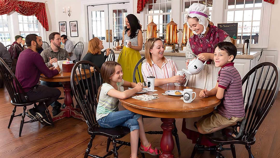 Tourists enjoying tea service at Abigail's Tea Room with a costumed server.