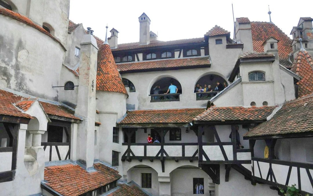Bran Castle courtyard with visitors exploring historic architecture.