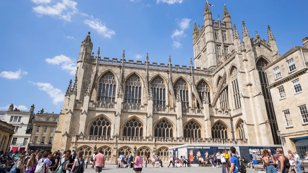 Bath Abbey with tourists in Bath, England, part of the Bridgerton Tour and Bath City Highlights.