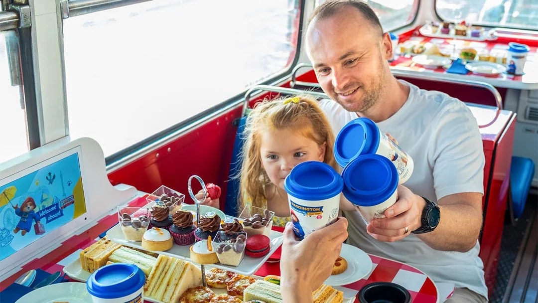Guests enjoying afternoon tea on the Paddington Bus with sandwiches and pastries.
