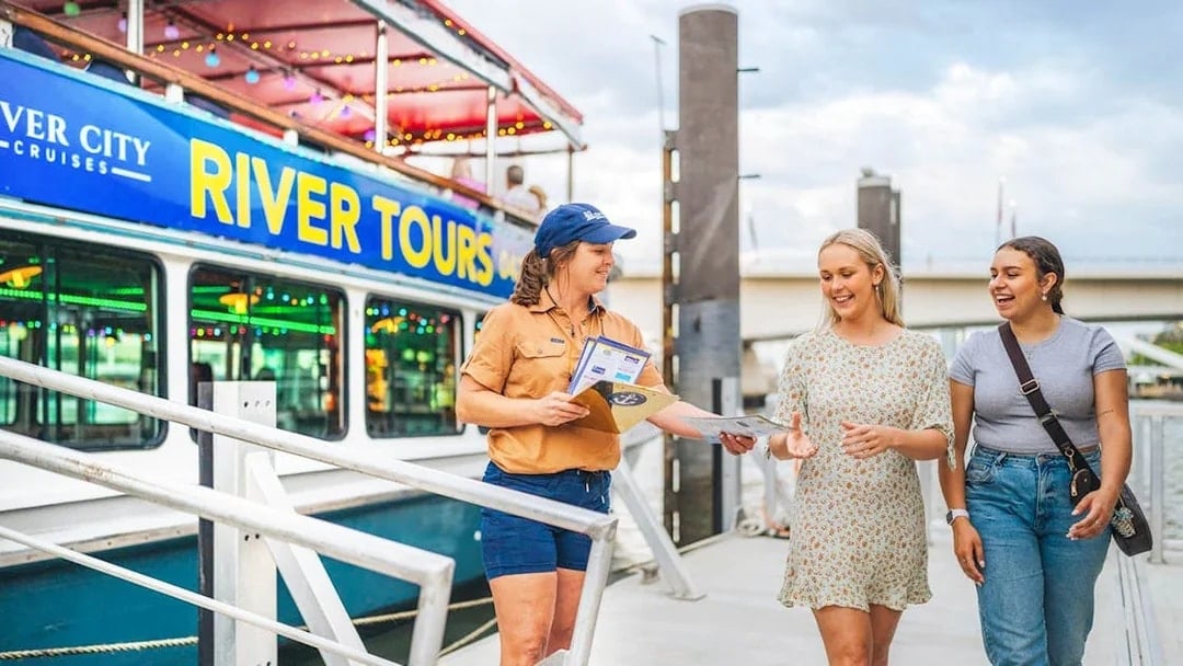River City Cruises staff member gives tour information to guests at Brisbane dock.