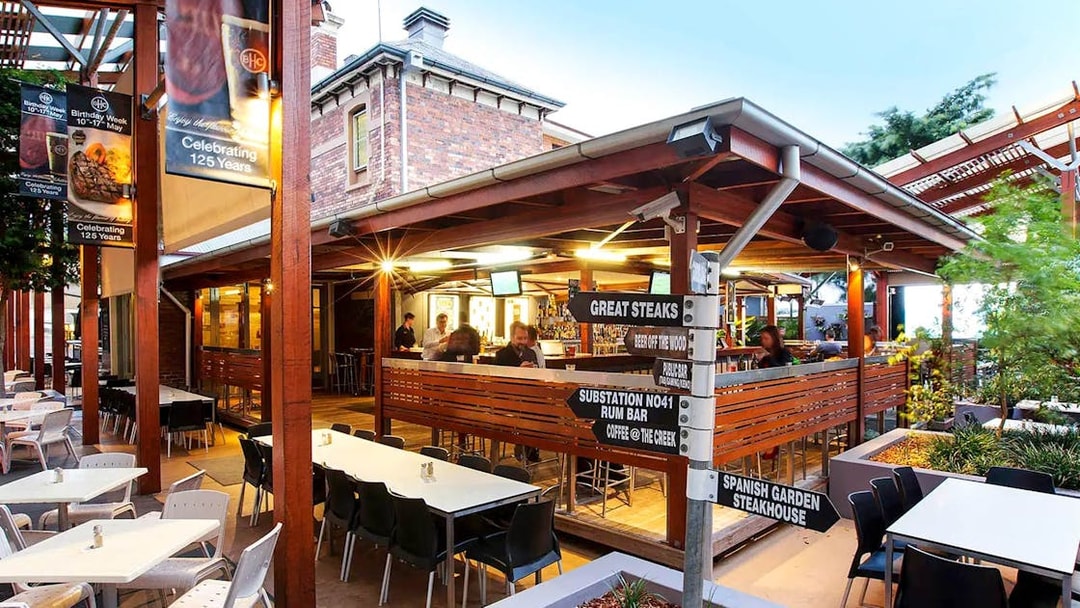 Outdoor dining area at riverside restaurant on Brisbane River lunch cruise.