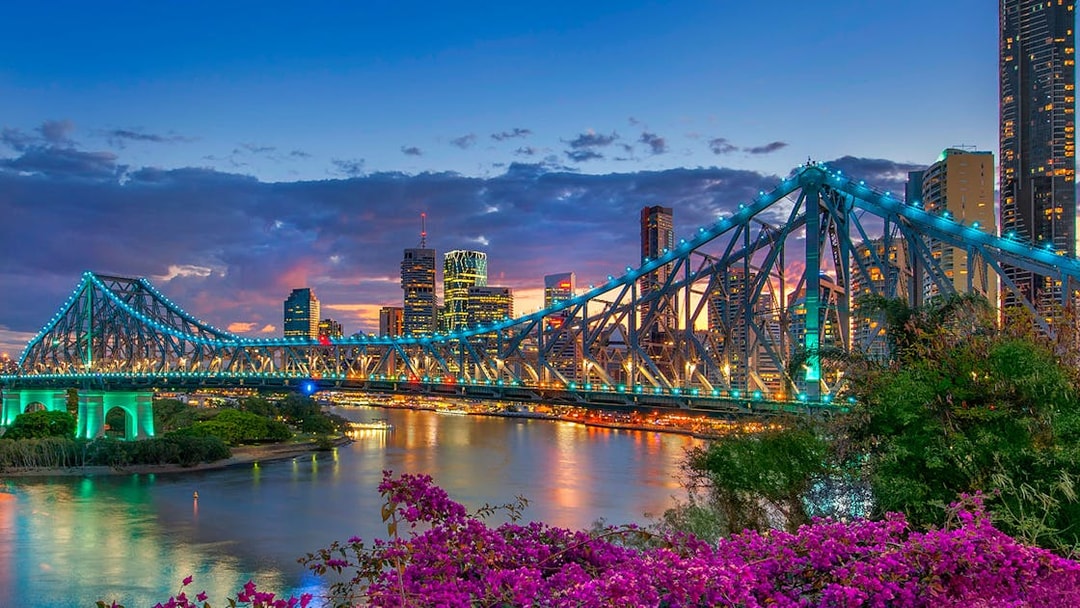 Brisbane Story Bridge at twilight with city skyline in the background.