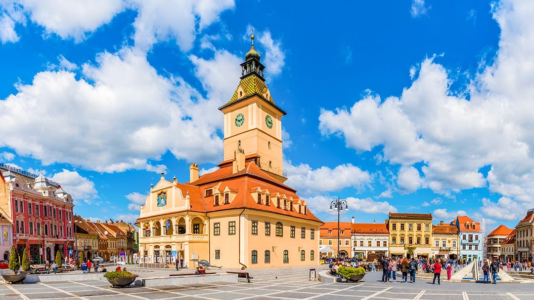 Council Square in Brasov with historic buildings and people walking.