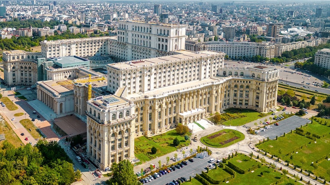 Aerial view of the Palace of Parliament in Bucharest, Romania, showcasing its grand architecture.