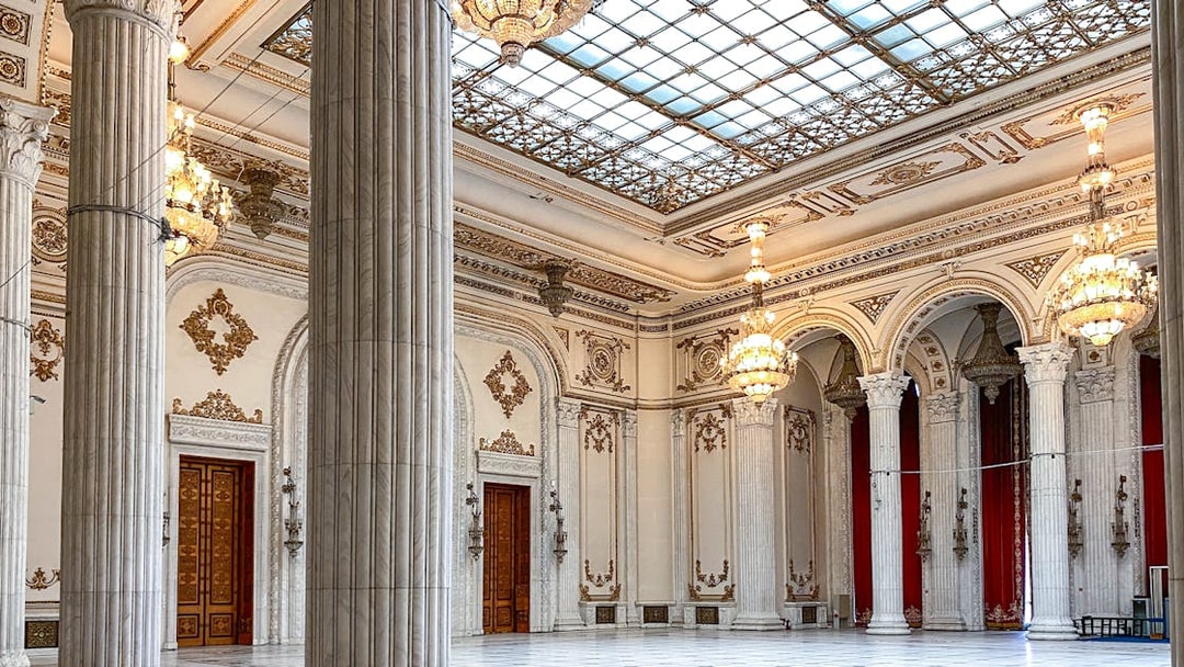 Grand hall with chandeliers and columns inside the Palace of Parliament, Bucharest, Romania.