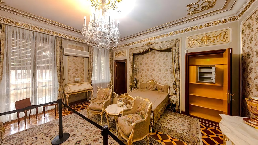 Interior of Ceaușescu Mansion bedroom with ornate decor and chandelier, Bucharest.