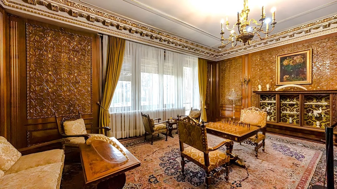 Interior of Ceaușescu Mansion in Bucharest with ornate wood paneling and vintage furniture.