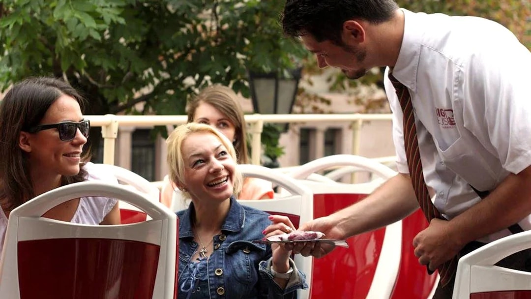 Tourists interacting with guide on Budapest Hop-On Hop-Off bus tour.