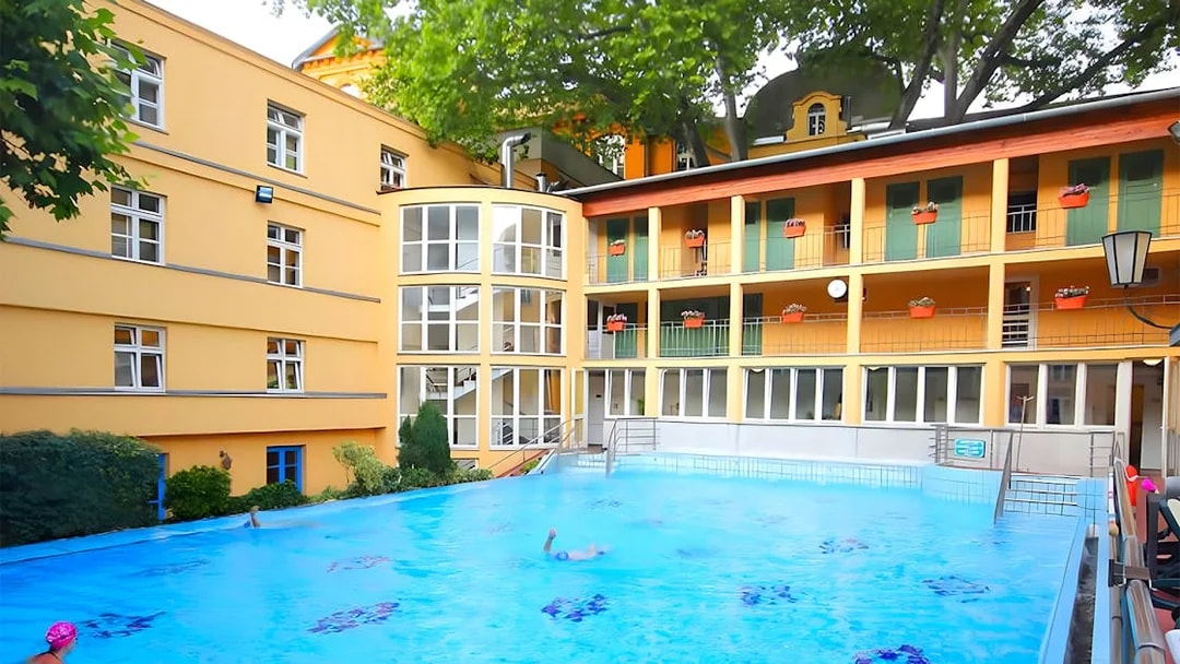 Lukacs Baths outdoor pool with swimmers in Budapest.