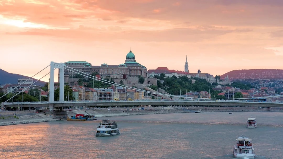 Danube River cruise with view of Buda Castle and Elizabeth Bridge in Budapest at sunset.