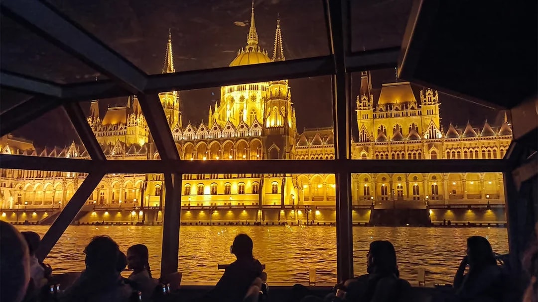 Hungarian Parliament Building illuminated at night viewed from a Budapest Danube River dinner cruise.