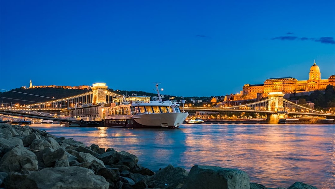 Dinner cruise on the Danube River with Buda Castle and Chain Bridge illuminated at night, Budapest.