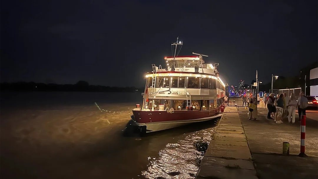 Dinner cruise boat docked on the Danube River in Budapest at night.