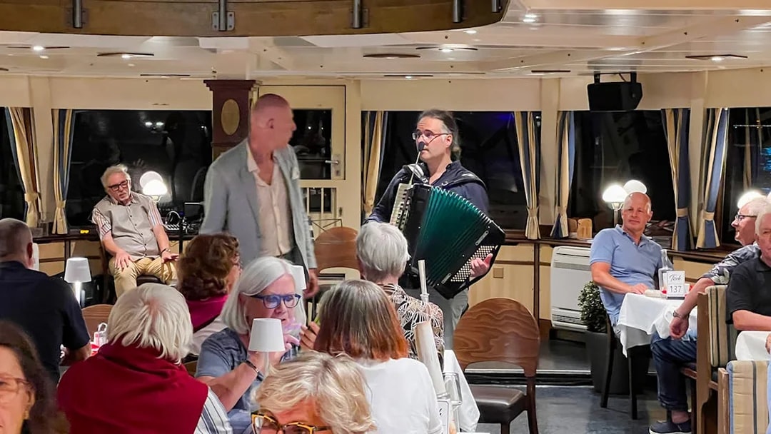 Accordion player performing for guests on Budapest Danube River dinner cruise.