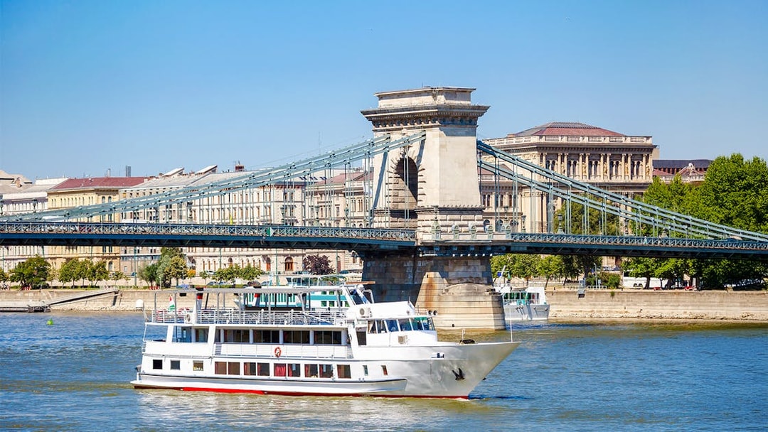 Cruise ship on Danube River passing under Chain Bridge in Budapest.