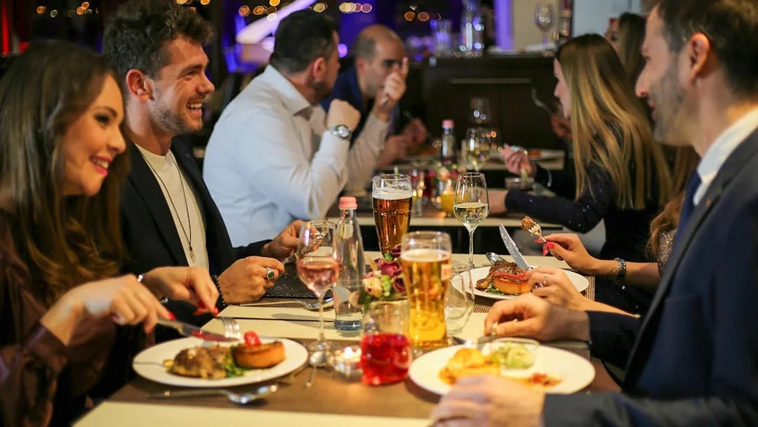 Guests dining on a Budapest dinner cruise with a piano battle show.