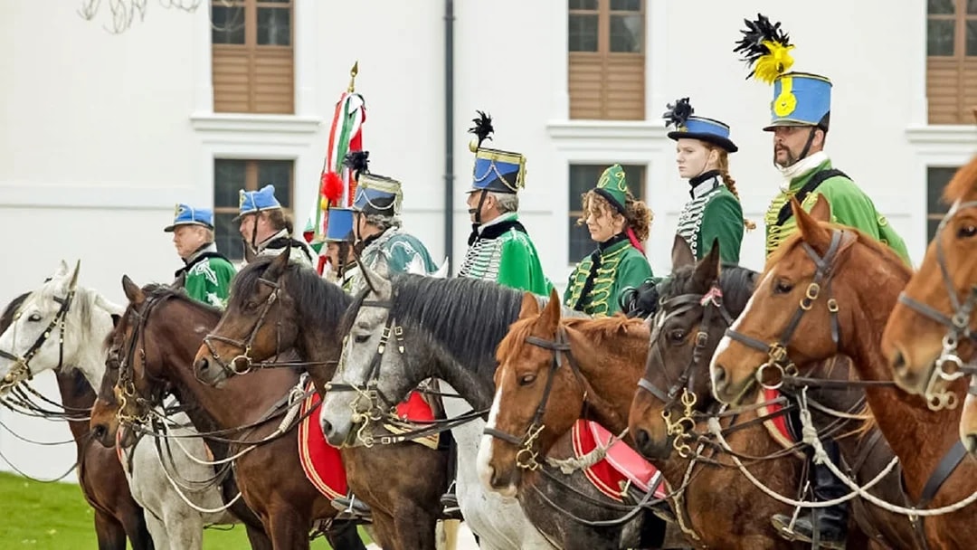 Hungarian hussars on horseback in traditional attire at Gödöllő Palace, Budapest tour.