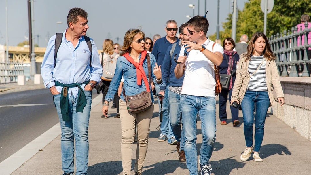 Visitors walking with a guide during the Grand City Tour near Parliament.