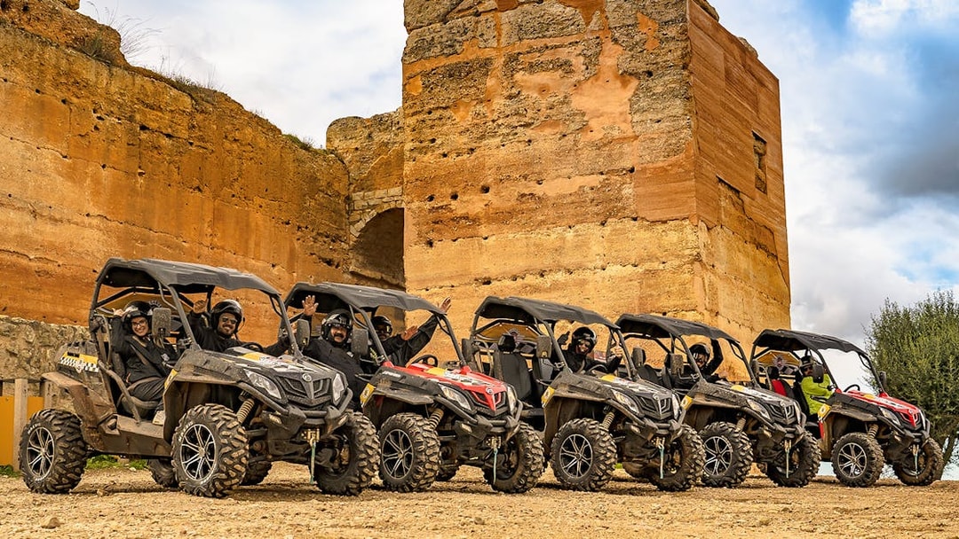 Buggy tour group in Algarve, Portugal, parked by ancient stone ruins.