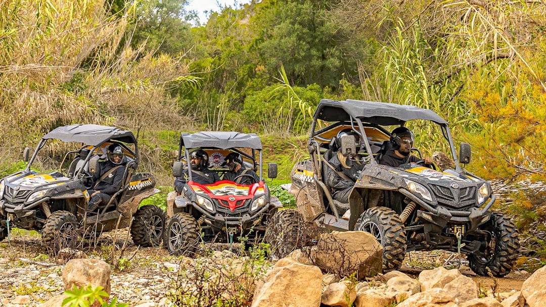 Buggy tour through rocky terrain in Algarve, Portugal with lush greenery in the background.