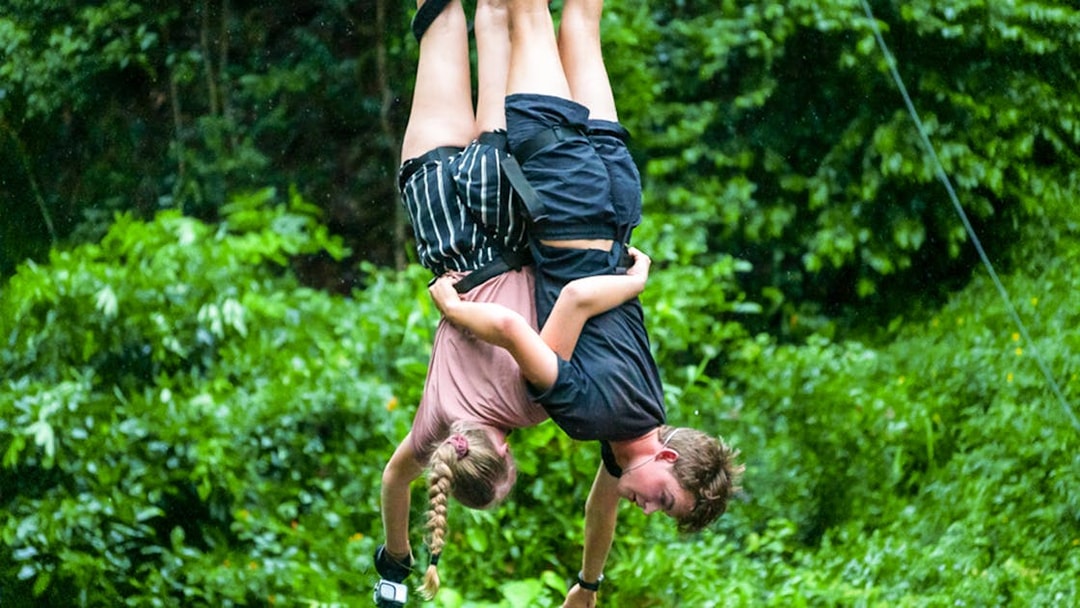 Two people bungy jumping in Cairns rainforest.