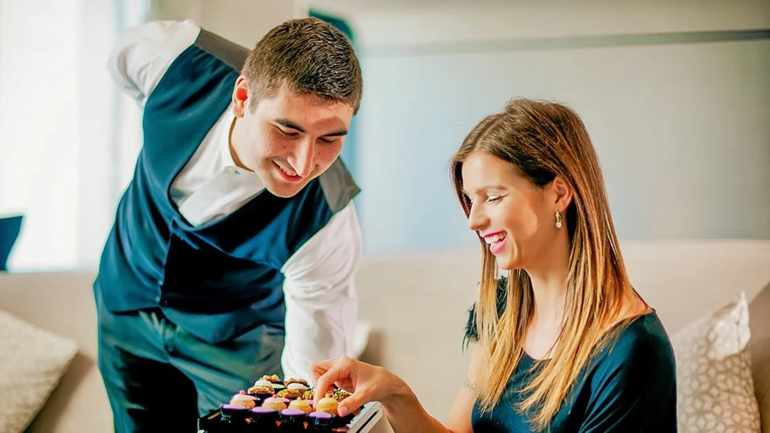 Server presenting cupcakes to a woman at Burj Khalifa cafe.