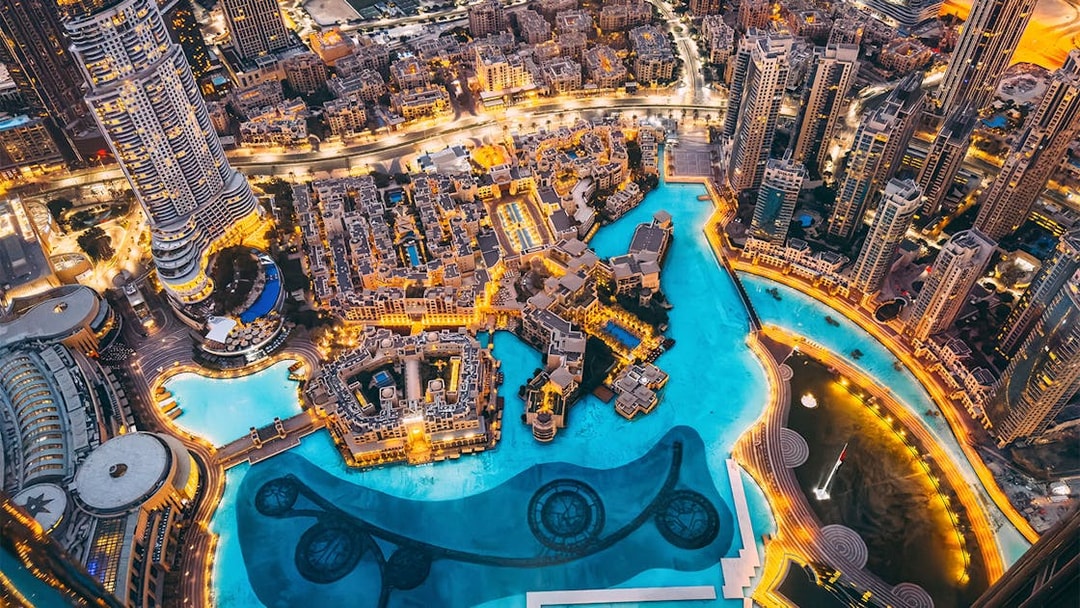 Panoramic view of Dubai city from Burj Khalifa Levels 124 & 125, featuring illuminated skyline.